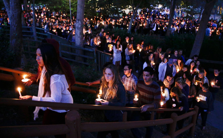 Image: People gather at a park for a candlelight vigil to honor the victims of Friday night's mass shooting on Saturday