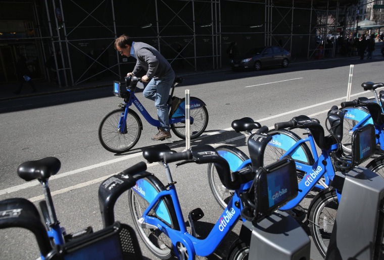 Image: A Citi Bike user pedals off from a bicycle station