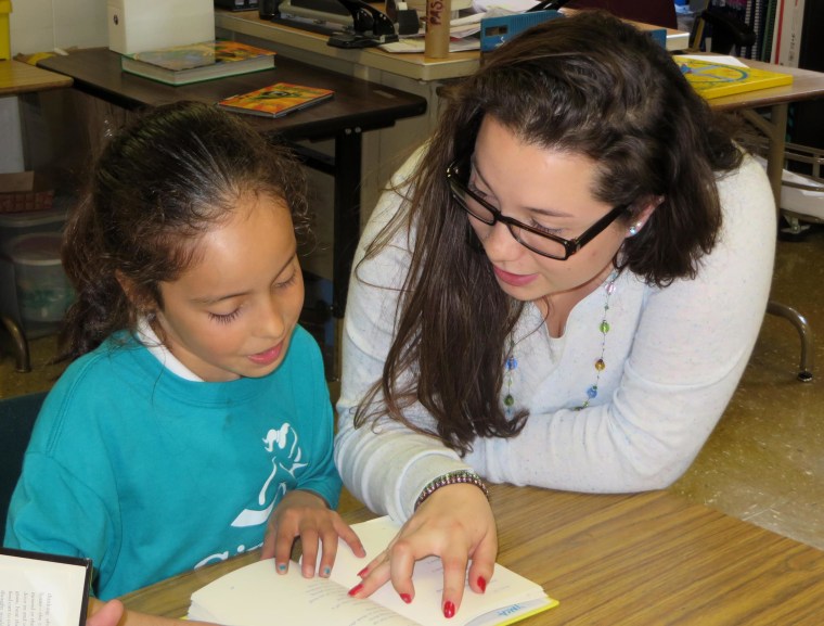 College student Priscila Trejo-Martinez, who was part of Mission Graduates' College Connect program as a high school student, now works as a Mission Graduates Program Assistant and is seen here reading aloud with Marshall 4th grader Joselyn.