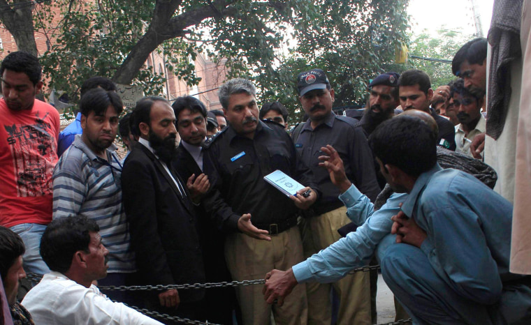 Image: Police collect evidence near body of Farzana Iqbal, killed by family members, at site near Lahore High Court building in Lahore