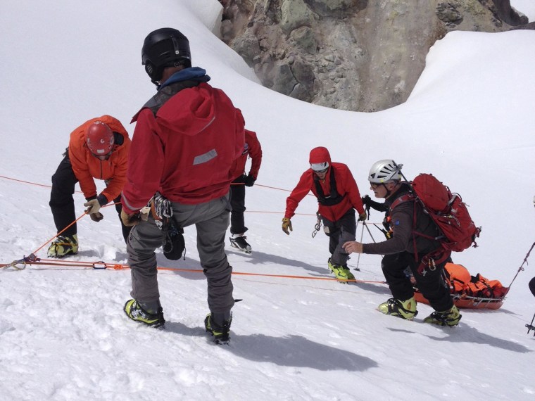 Image: A rescue team tends to rescued hiker James Michael Adams after rescue on Mt. Hood, Oregon