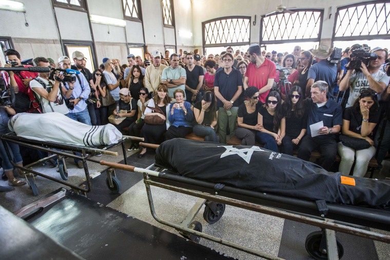 Image: Relatives mourn over the bodies of Emanuel and Miriam Riva on Tuesday