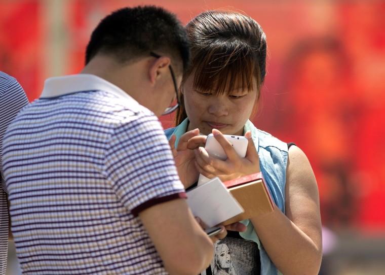 Image: People use smartphones on Tiananmen Square in Beijing