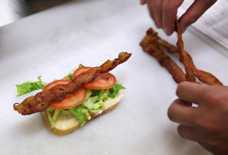 Image: A cook makes a bacon sandwich.