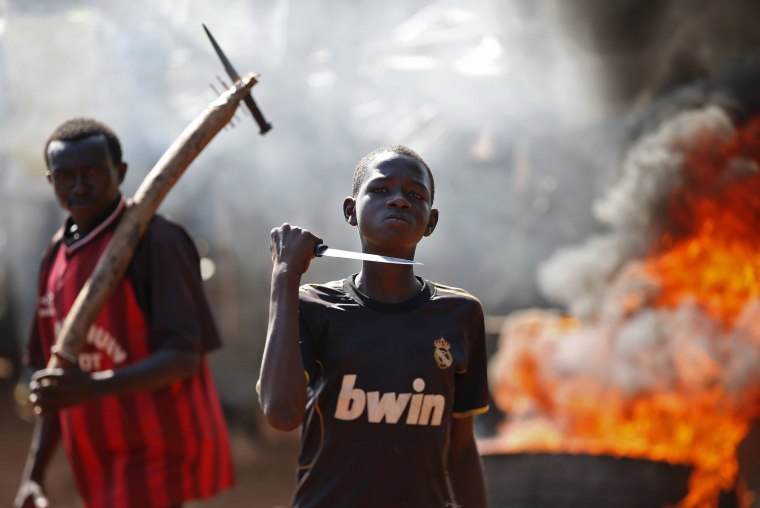 A boy gestures in front of a barricade on fire during a protest after French troops opened fire at protesters blocking a road in Bambari May 22, 2014. REUTERS/Goran Tomasevic (CENTRAL AFRICAN REPUBLIC - Tags: CIVIL UNREST POLITICS TPX IMAGES OF THE DAY MILITARY)