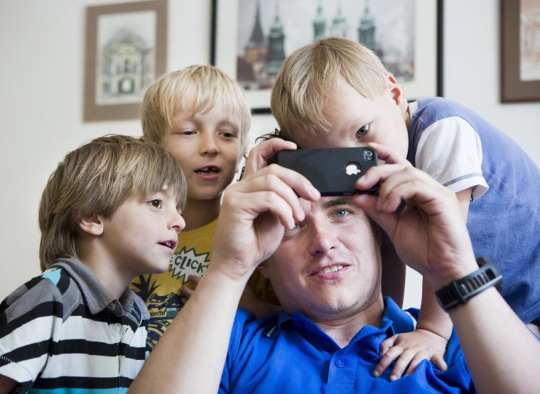 Man with smart phone and young children