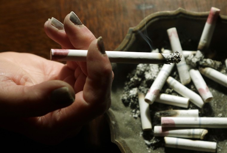 Image: A woman smokes a cigarette at her home in Hayneville, Ala on March 2, 2013