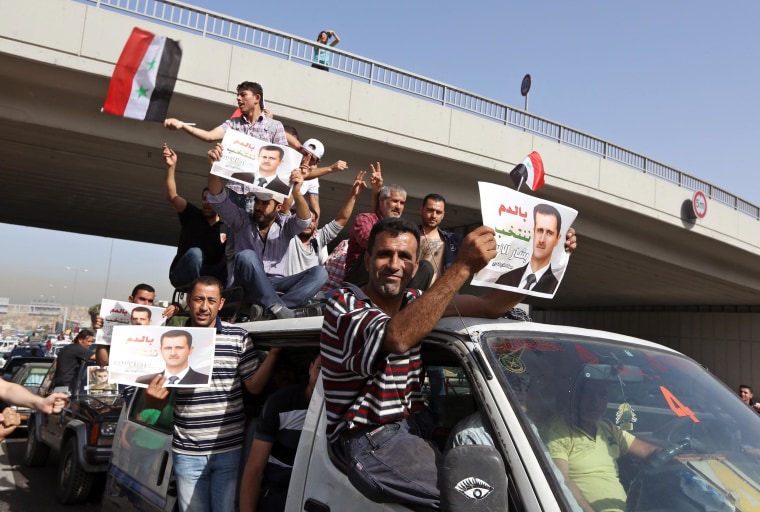 Image: Syrians who live in Lebanon carry portraits of Syrian President Bashar Assad and their national flags as they drive towards to the Syrian embassy to vote in the presidential election in Yarze, east of Beirut, Lebanon, Wednesday, May 28, 2014.