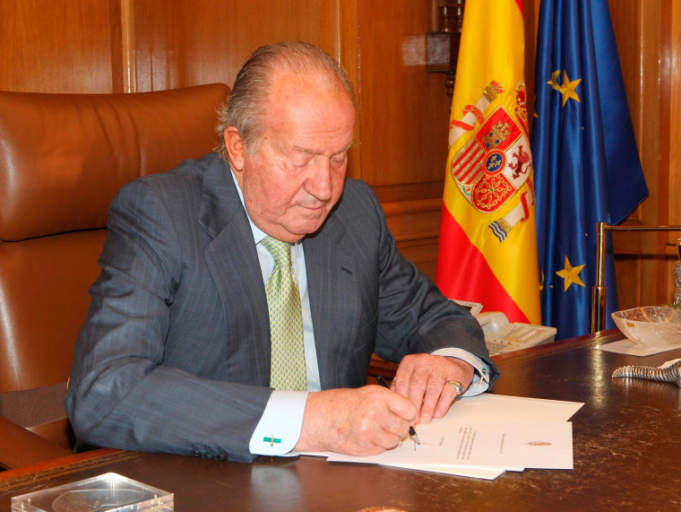 Image: Spain's King Juan Carlos signs his abdication at the Zarzuela Palace