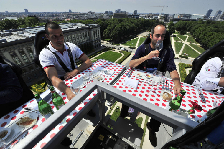 Image: Diners take lunch suspended in the air on Monday above the Parc du Cinquantenaire in Brussels