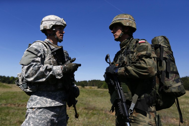 Image: Captain Tomasz Neuman, company commander of Polish 6 Airborne Brigade, and Captain Tadeusz Borawski, company commander of the U.S. Army's 173rd Infantry Brigade Combat Team, speak in Poland