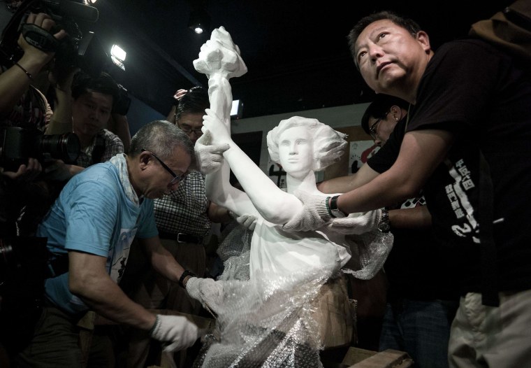 Image: A "statue of democracy" is unpacked by Lee Cheuk-yan, right, at the  June 4 Memorial museum in Hong Kong