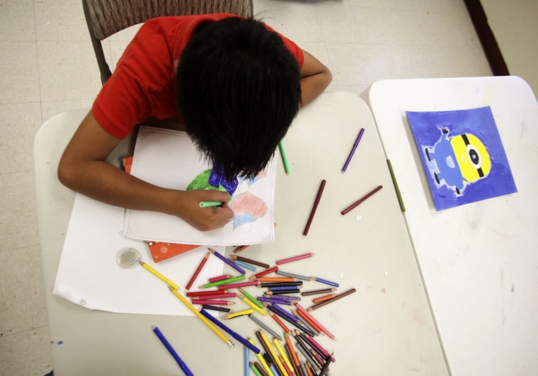 Image: A boy draws at the shelter for underage immigrants and repatriated minors "Mexico, my home" in Ciudad Juarez