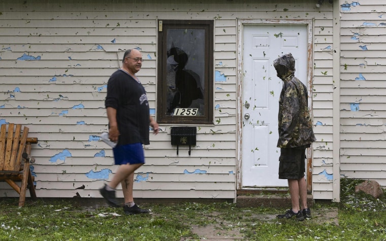 Image: Blair residents survey hail damage in the pouring rain following a severe thunderstorm in Blair, Neb.