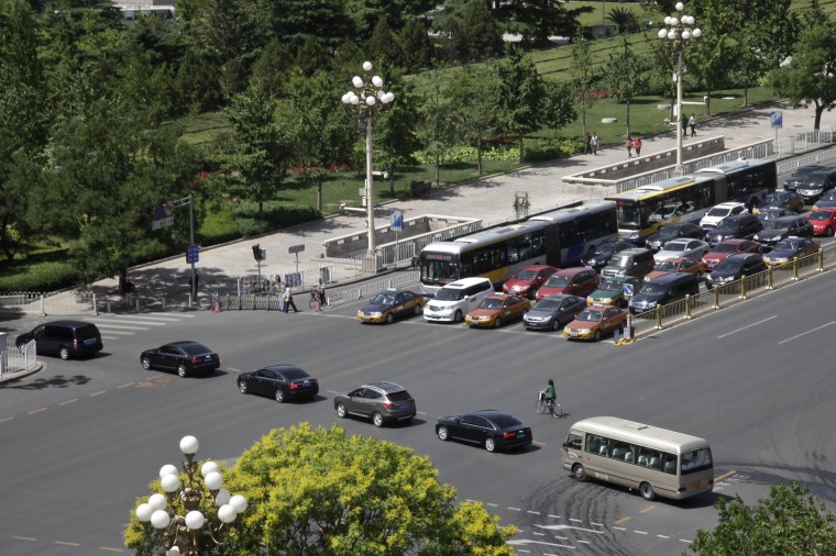 Image: A convoy of cars drive across Beijing's Changan Blvd., near Tiananmen Square