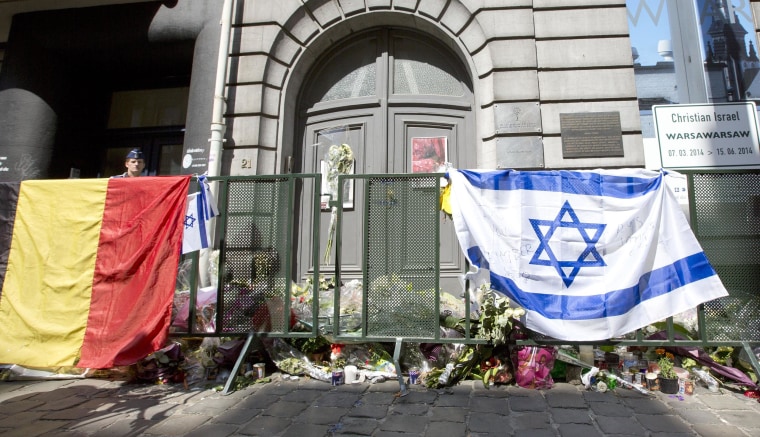 Image: The Belgian and Israeli flag hang on a rail in front of candle and flower tributes a for the victims of a shooting at the Jewish Museum in Brussels, on June 2