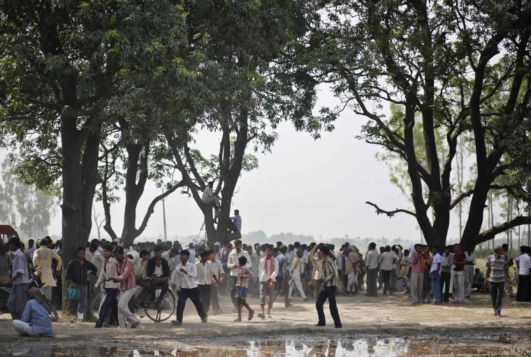 Image: Onlookers stand at site where two teenage girls, who were raped, were hanged from tree at Budaun