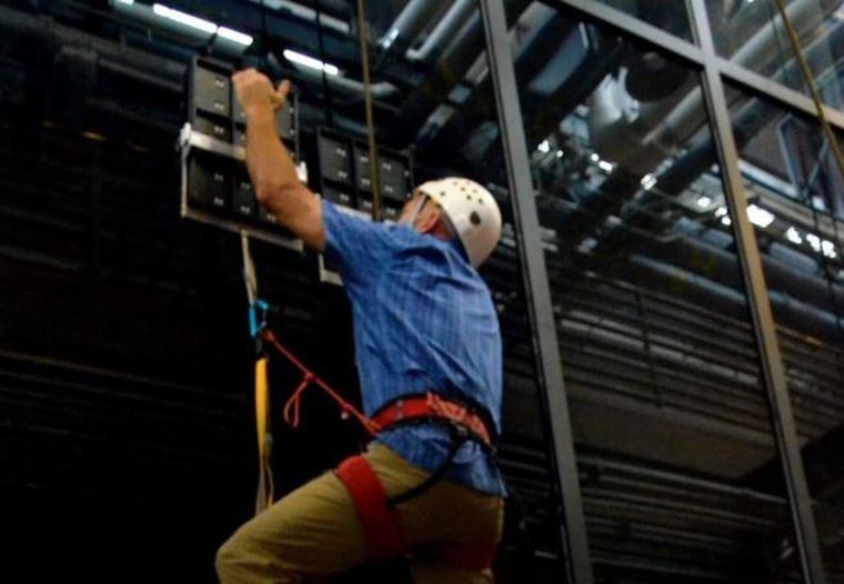 DARPA's climber ascends the glass wall using the Z-Man paddles.