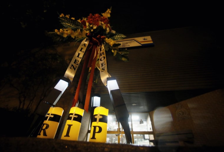 Image: Flowers and candles at the RCMP station in Moncton
