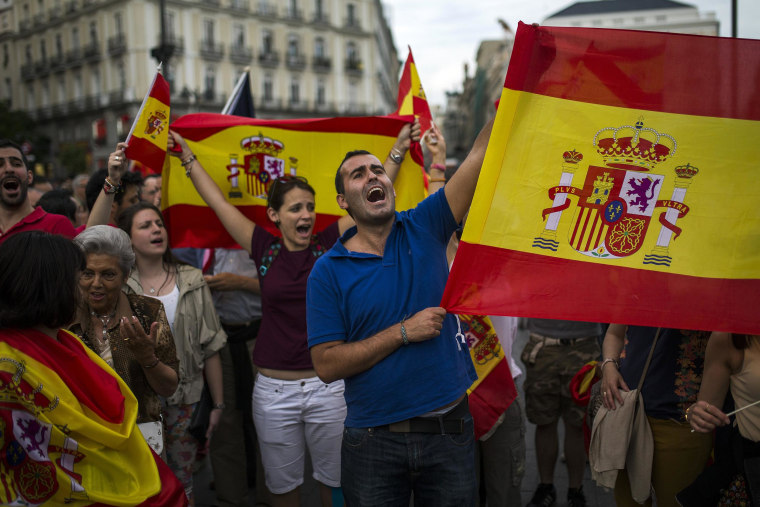 Image: Dozens of demonstrators gather and wave Spanish flags around the monument of Charles III, a former King of Spain, during a demonstration in support of the Spanish Monarchy in the main square of Madrid, Spain