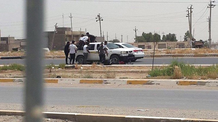 Image: Students of Anbar university ride on the back of a truck as they leave the university building in Ramadi city