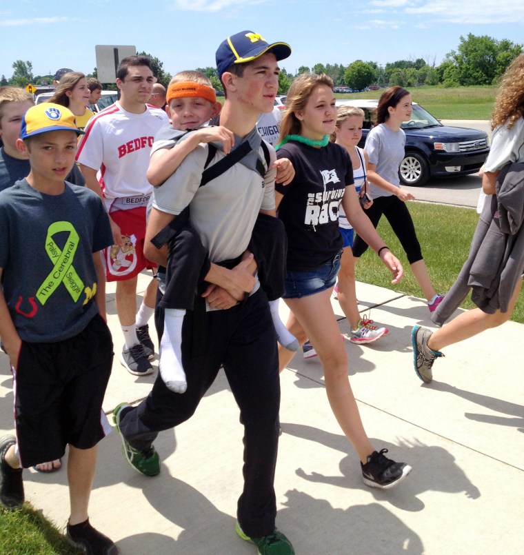 Image: Hunter Gandee, 14, walks in Saline, Mich., on Sunday, during the second day of his two-day, 40-mile “Cerebral Palsy Swagger” walk