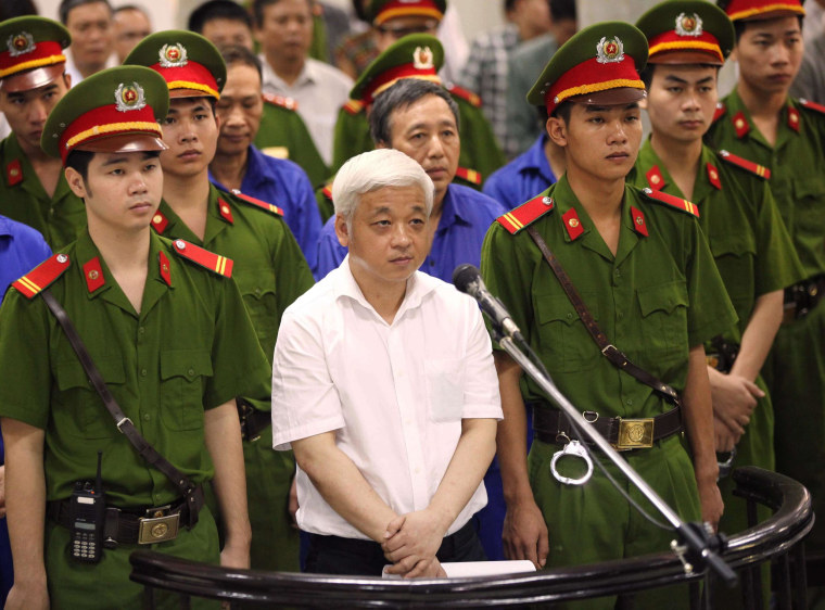 Image: Former Vietnamese banking tycoon Nguyen Duc Kien, 50, stands listening to the verdict read at the Hanoi People's Court