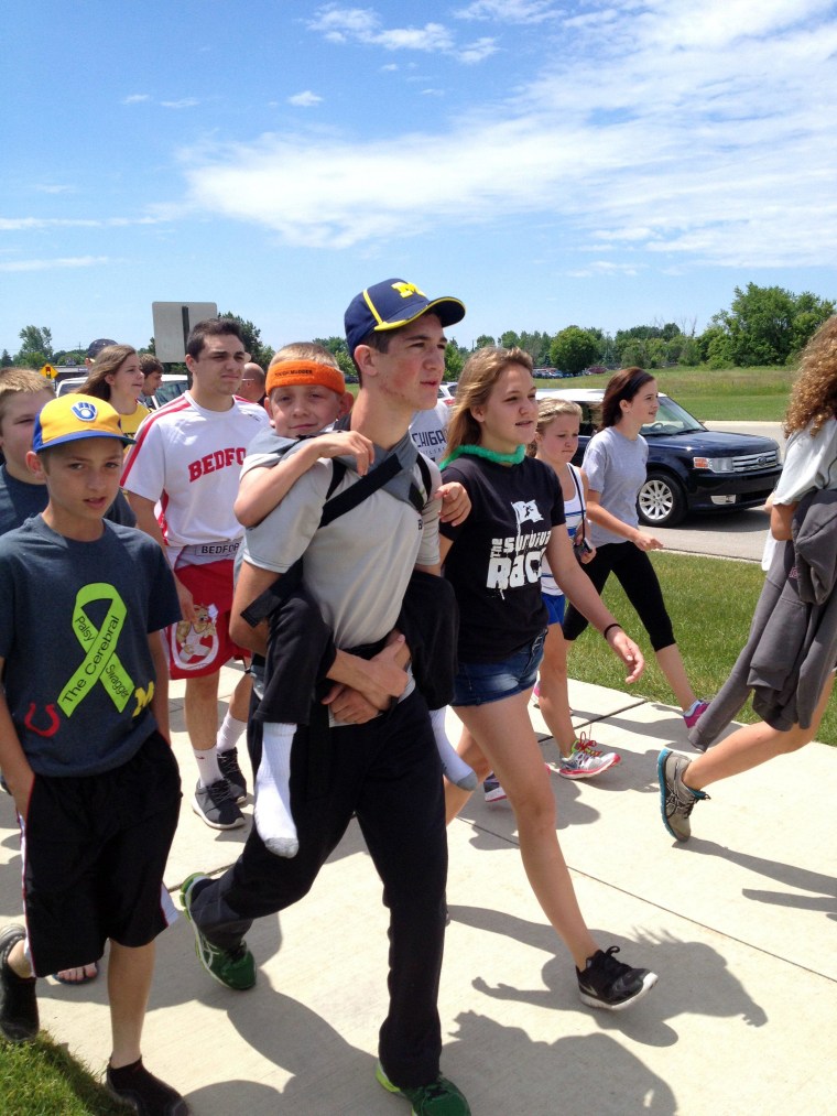Image: Hunter Gandee, 14, walks in Saline, Mich., on Sunday, June 8, 2014, during the second day of his two-day, 40-mile “Cerebral Palsy Swagger” walk