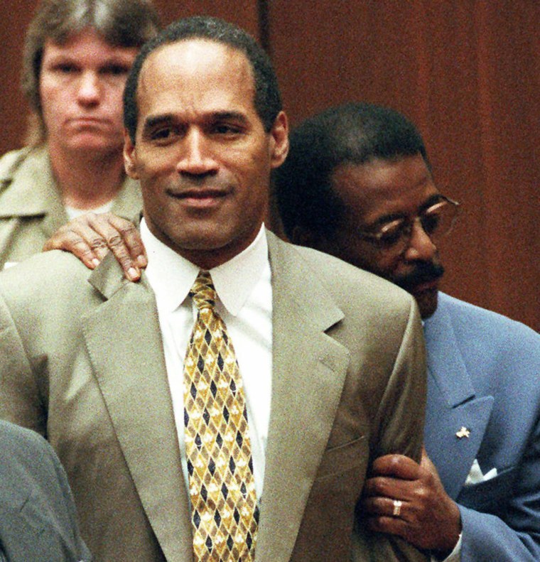 Attorney Johnnie Cochran Jr. holds onto O.J. Simpson