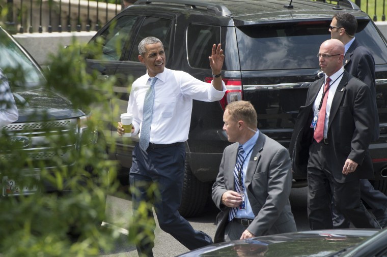 Image: President Barack Obama waves to members of the news media after making a surprise visit to a nearby Starbucks