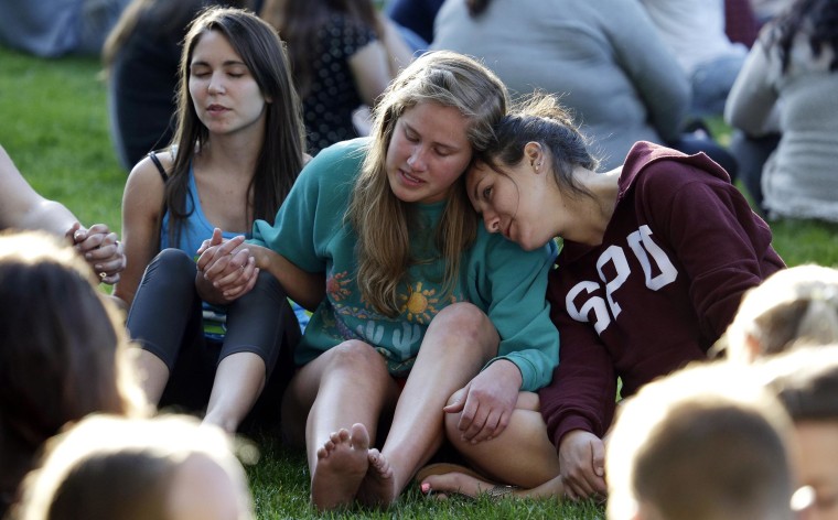 Image: Students from Seattle Pacific University gather outside in a spontaneous prayer circle after a church service was full, following a shooting on the campus of the university on June 5