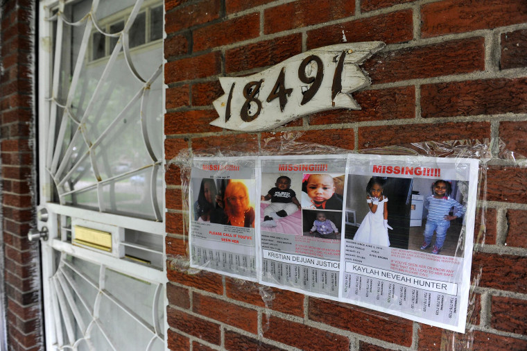 Image: Flyers of a missing woman and children are taped to the brick home of Alicia Fox