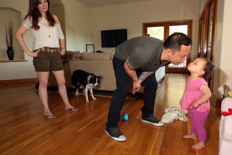 Jet Tila kisses his 19-month old daughter, Amaya, while his wife, Ali, looks on in their Los Angeles home.