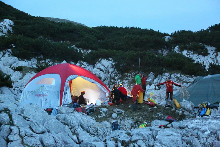 Image: Rescue workers gather at a tent near the entrance to the Riesending underground cave