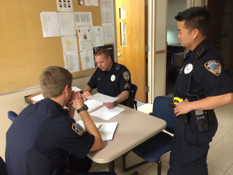 Lincoln Police Officer Tu Tran meets with other officers before heading out on patrol.