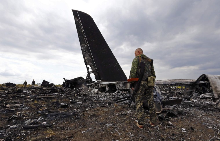 Image: Pro-Russian separatists walk at the site of the crash of the Il-76 Ukrainian army transport plane in Luhansk