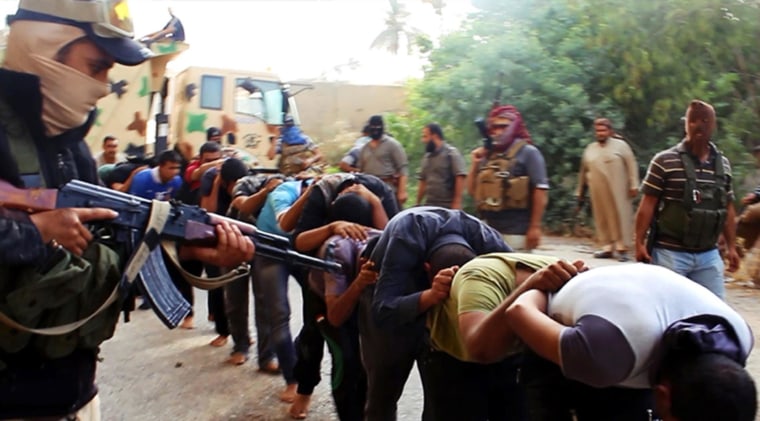 Image: Militants from ISIL lead away captured Iraqi soldiers in plain clothes after taking over a base in Tikrit