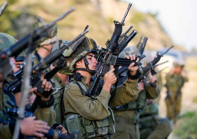 Image: Israeli soldiers load their weapons near Hebron