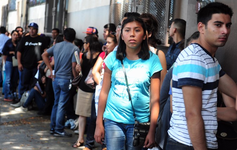 Image: Young people wait in line to enter the o