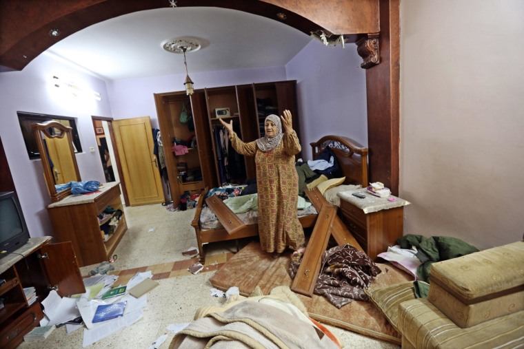 Image: Eyad Terawe checks the damage to her family home after Israeli troops arrest her son