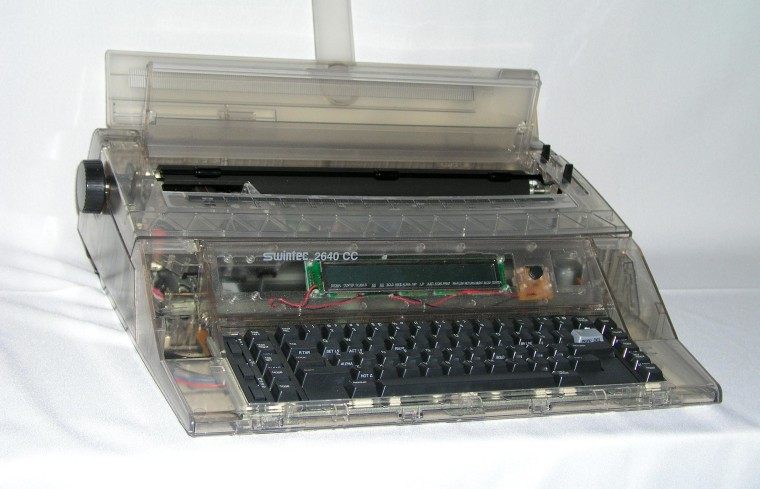Image: A typewriter made by Swintec with a clear plastic shell.