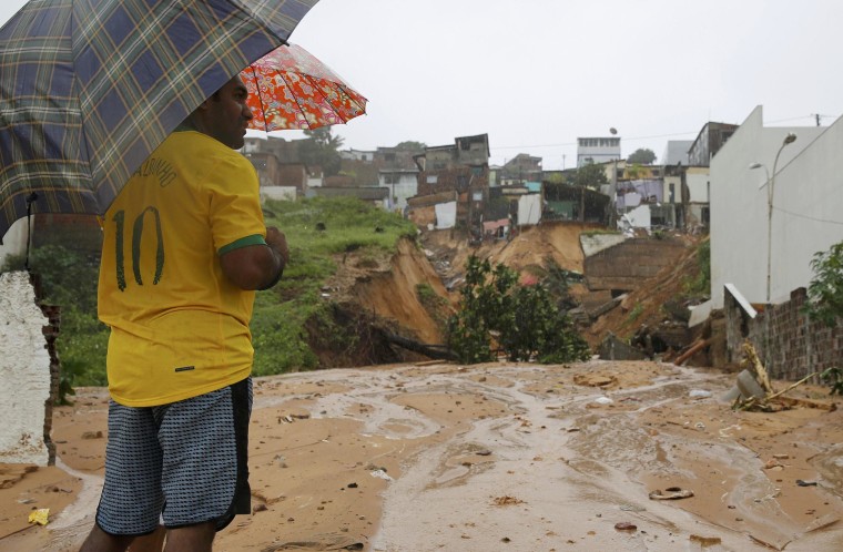 Image: Man looks at the site of house destroyed by a landslide in Mae Luiza near Nata