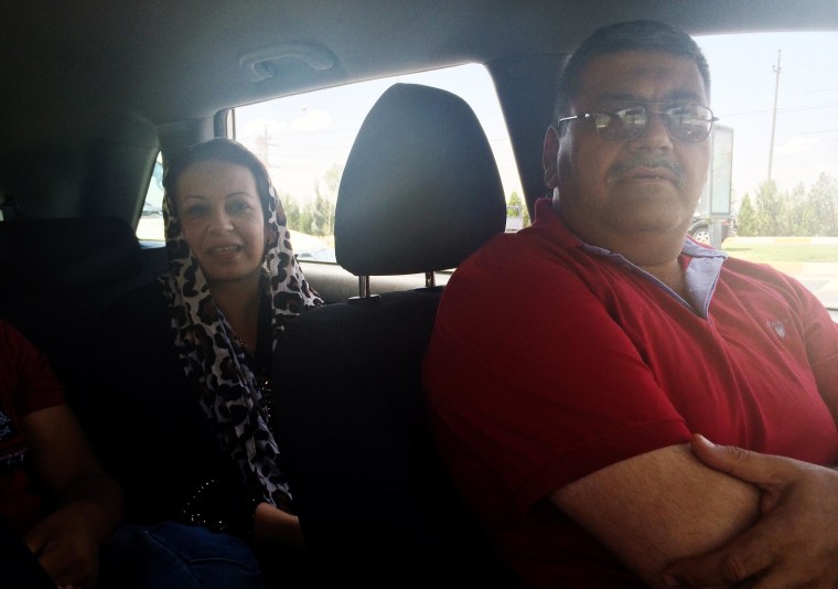Image: Ikram and her husband Murad sit in a long line of cars waiting to fill their car with gas