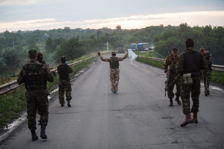 Image: Pro-Russian fighters wave a white flag to start a handover of the bodies of Ukrainian troops killed