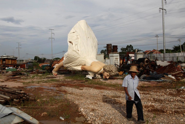 Image: Man walks past giant statue of U.S. actress Marilyn Monroe, dumped at a garbage collecting company in Guigang