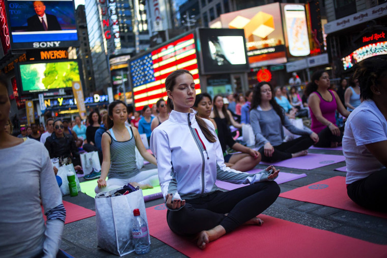 Image: People practice yoga in Times Square as part of a Summer Solstice celebration in New York