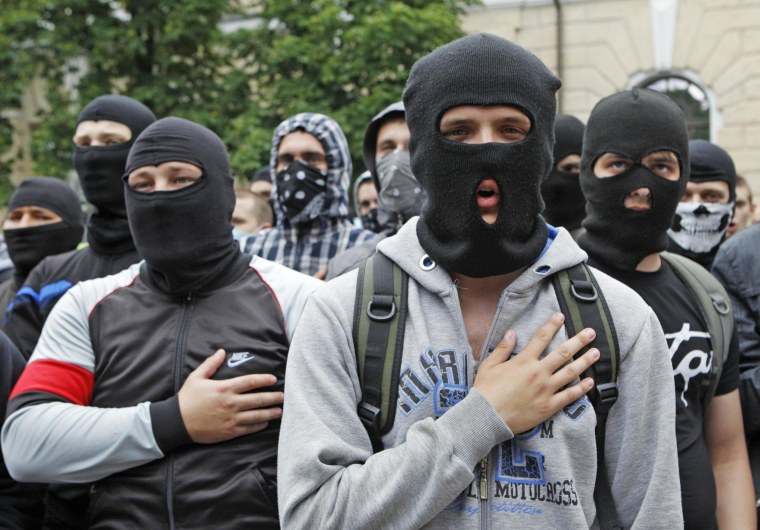 Image: People wearing balaklavas sing the national anthem during a pro-Ukrainian anti-separatist rally near Kiev Pechersk Lavra monastery, in Kiev
