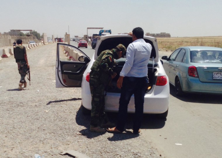 Image: Kurdish security forces check cars along a highway outside Mosul, Iraq.
