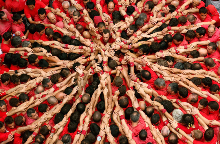 Image: Castellers Colla Joves Xiquets de Valls start to form a human tower called "castells" during the Sant Joan festival at Plaza del Blat square in Valls