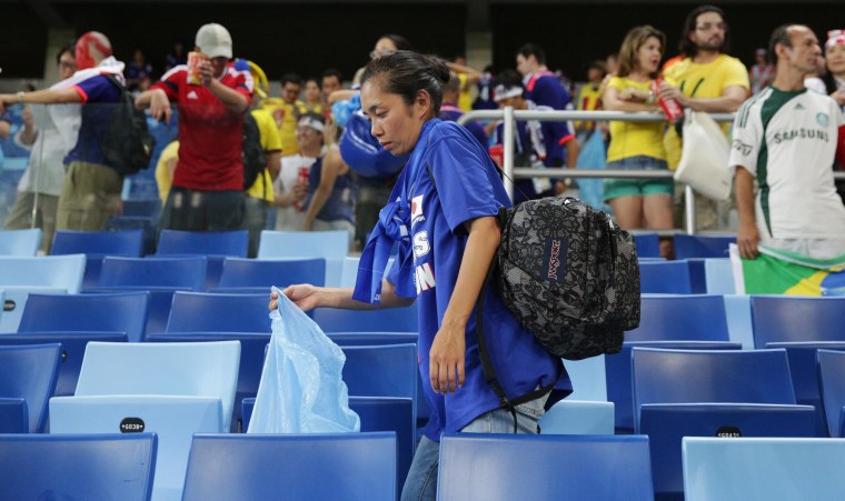 Image: A Japan fan helps collect litter from the stadium after the Japan and Colombia match on Tuesday.